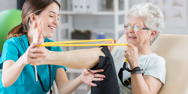 Rehabilitation nurse helping a patient with therapy for knee